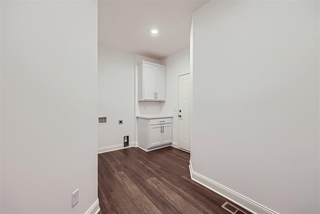 laundry area with hookup for a washing machine, cabinets, dark wood-type flooring, and hookup for an electric dryer