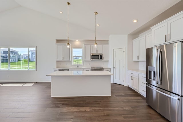 kitchen featuring white cabinets, appliances with stainless steel finishes, hanging light fixtures, and a kitchen island