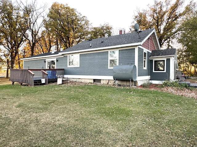 rear view of house featuring a yard and a deck