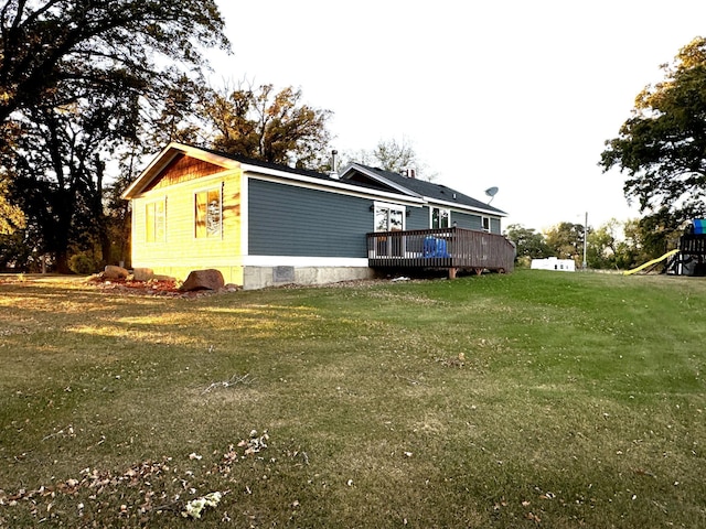 view of property exterior featuring a wooden deck and a lawn