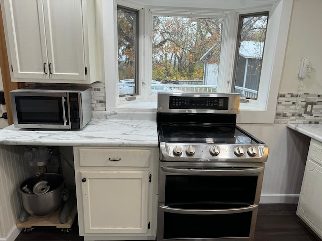 kitchen with appliances with stainless steel finishes, decorative backsplash, white cabinetry, and light stone counters