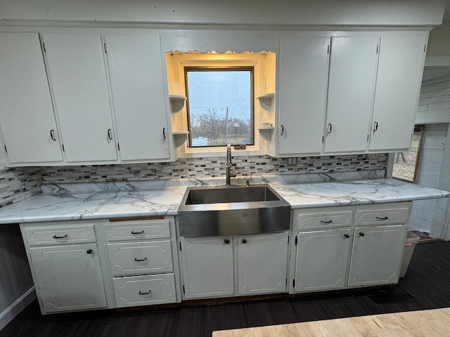 kitchen featuring tasteful backsplash, light stone counters, white cabinetry, dark hardwood / wood-style floors, and sink