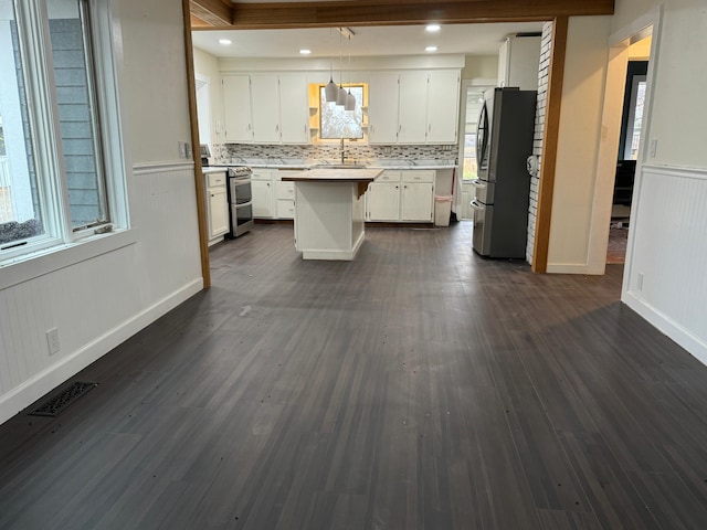 kitchen featuring a center island, white cabinets, stainless steel appliances, and dark hardwood / wood-style floors