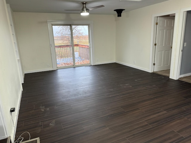 empty room with ceiling fan and dark hardwood / wood-style flooring