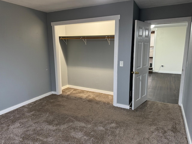 interior space with a closet and dark carpet