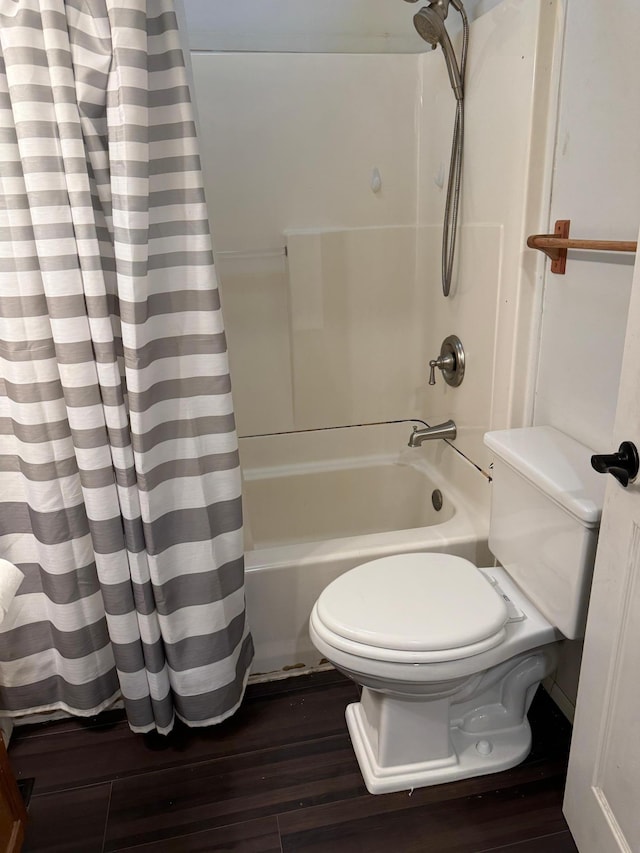 bathroom with shower / bath combo with shower curtain, wood-type flooring, and toilet