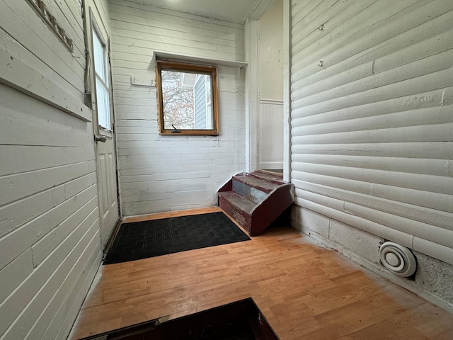 interior space with wood walls and hardwood / wood-style floors