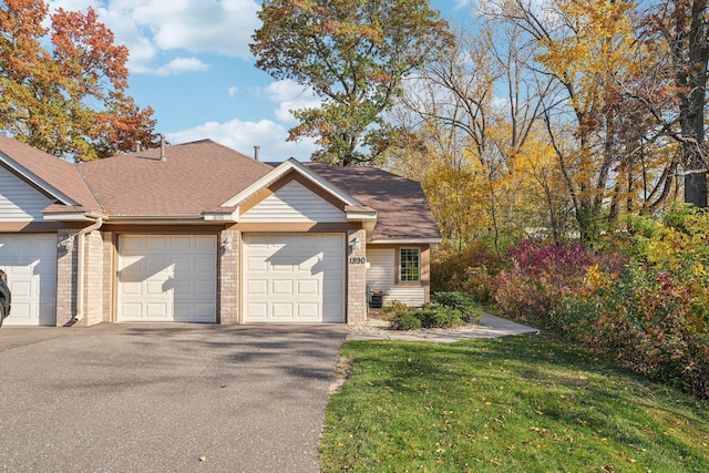 view of front of home with a front yard and a garage