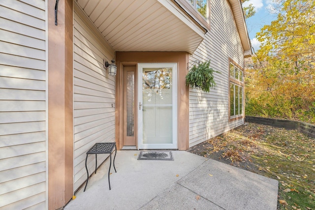 view of exterior entry with a patio area