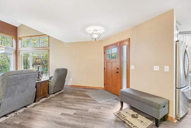 entryway with vaulted ceiling and light wood-type flooring