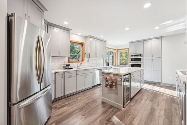 kitchen featuring sink, a kitchen island, stainless steel appliances, and light hardwood / wood-style floors