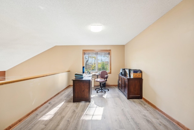 office area with lofted ceiling, a textured ceiling, and light wood-type flooring