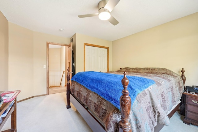 bedroom featuring light colored carpet, a closet, and ceiling fan