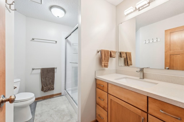 bathroom with vanity, a textured ceiling, toilet, and walk in shower