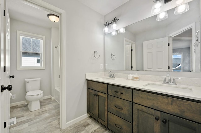 full bathroom featuring hardwood / wood-style floors, vanity, toilet, and shower / tub combination