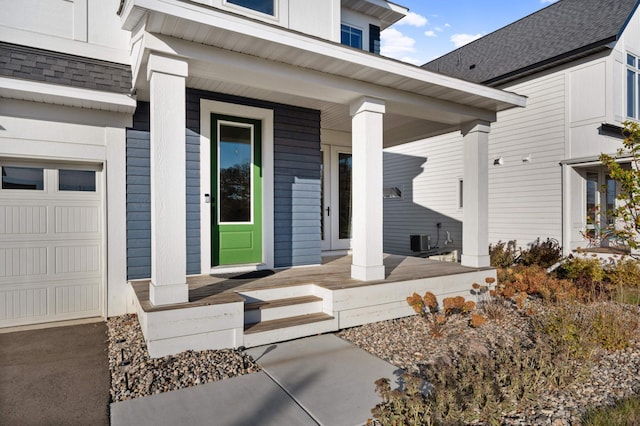 property entrance with central AC, covered porch, and a garage