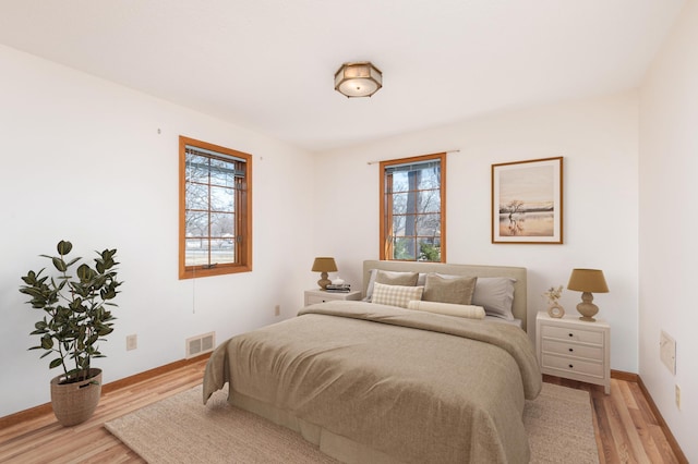 bedroom featuring light wood-type flooring, multiple windows, and visible vents