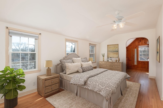 bedroom featuring a ceiling fan, vaulted ceiling, light wood-style floors, and baseboards