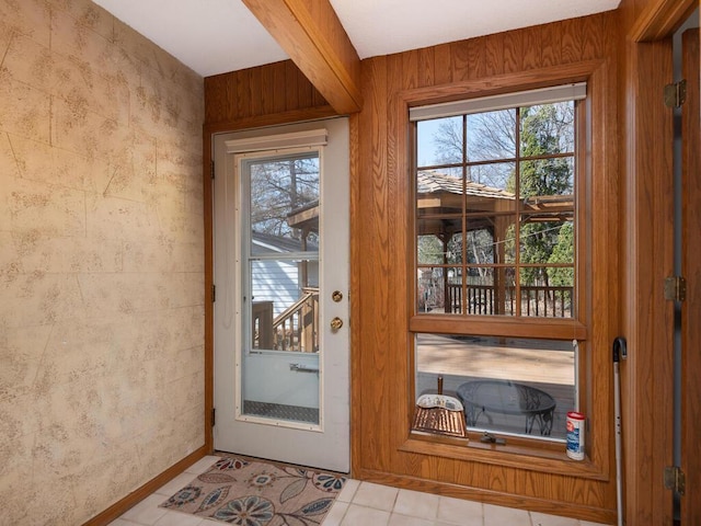 doorway to outside featuring tile patterned flooring and baseboards