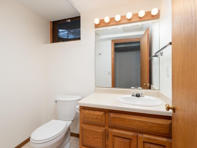 bathroom with vanity, toilet, and baseboards