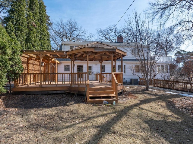 rear view of property with central air condition unit, a deck, a gazebo, a shingled roof, and a chimney