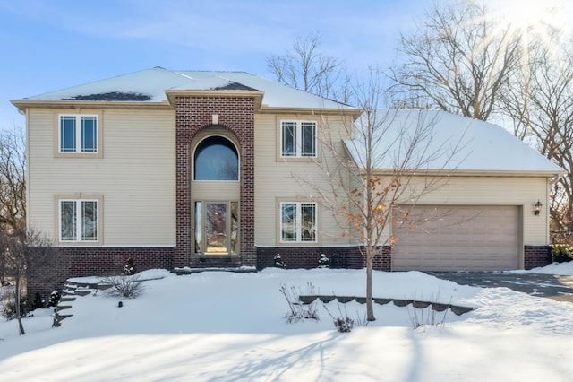 traditional-style home featuring a garage and brick siding