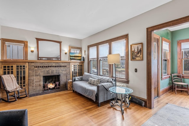 living room featuring a brick fireplace and wood-type flooring