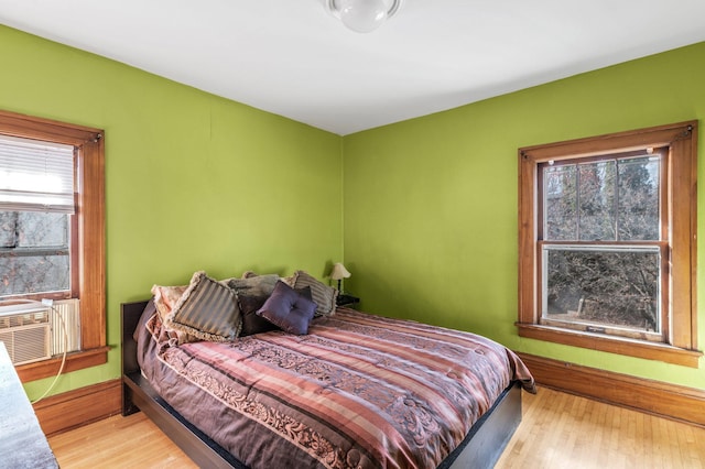 bedroom with multiple windows and light hardwood / wood-style flooring