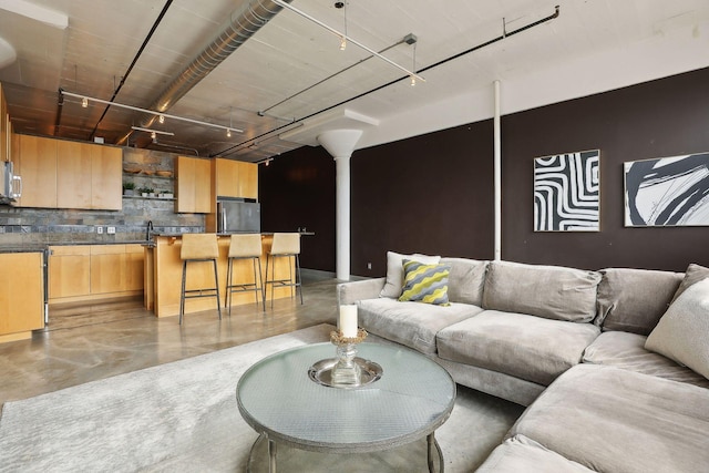 living room with ornate columns and concrete floors