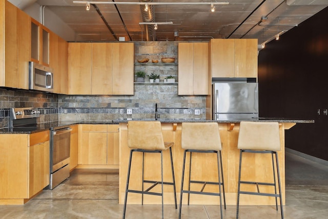 kitchen featuring appliances with stainless steel finishes, a kitchen bar, and a kitchen island