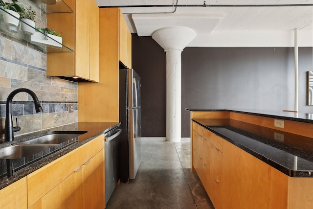 kitchen with dark stone countertops, sink, tasteful backsplash, and appliances with stainless steel finishes