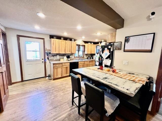 kitchen with dishwasher, light hardwood / wood-style flooring, a breakfast bar, refrigerator, and light brown cabinetry