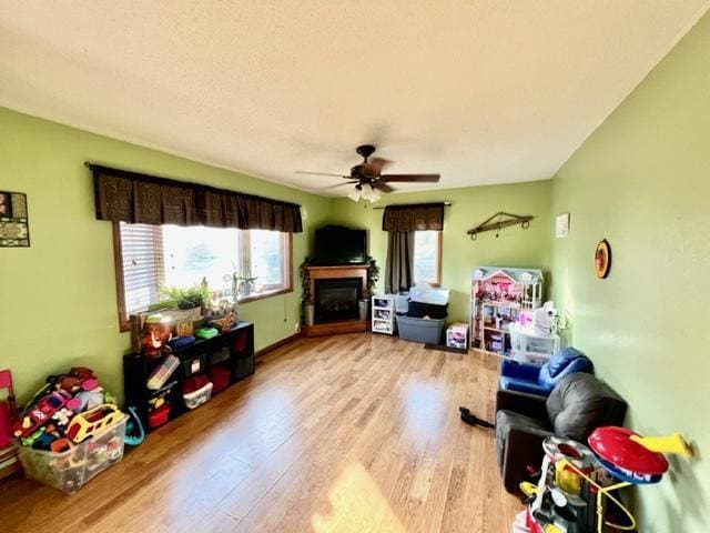 game room with ceiling fan and light wood-type flooring