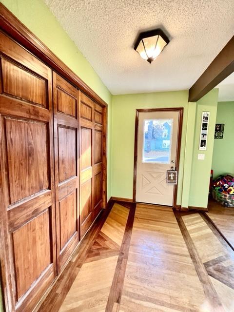 entryway featuring light hardwood / wood-style flooring and a textured ceiling