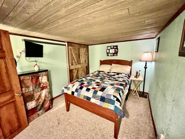 bedroom with carpet floors and wooden ceiling