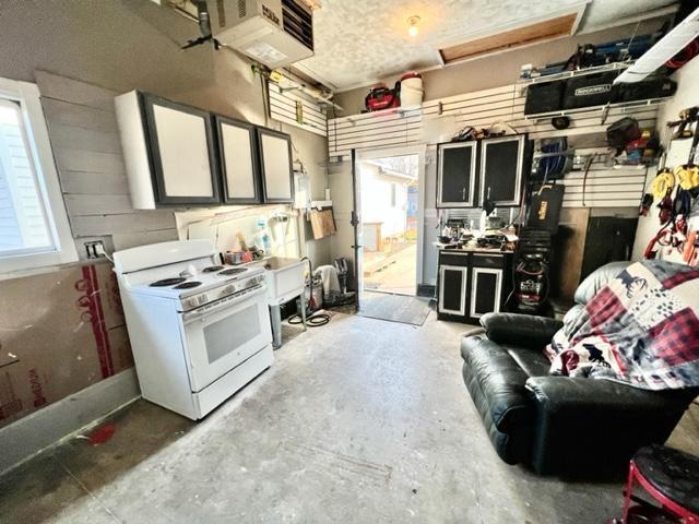 kitchen featuring white gas range oven and concrete flooring