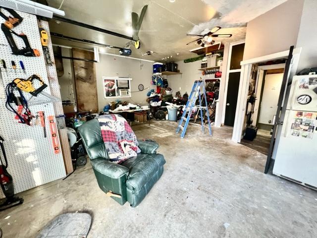 garage with white fridge and ceiling fan