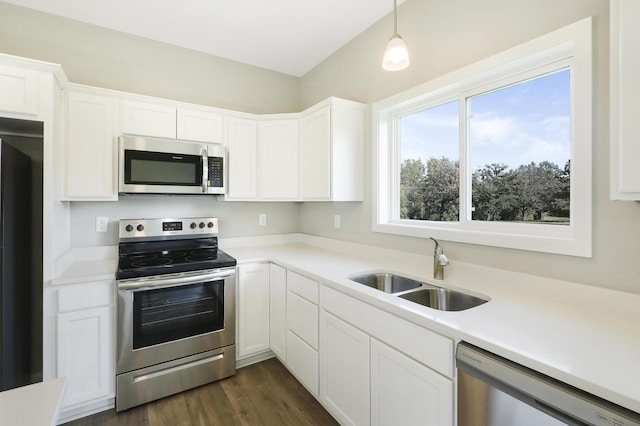 kitchen with stainless steel appliances, hanging light fixtures, sink, and white cabinetry