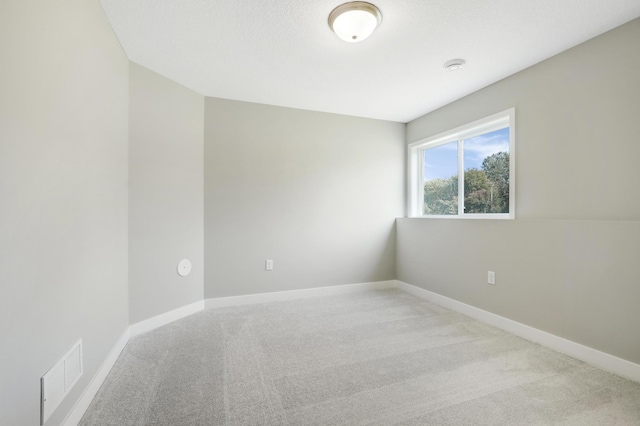 spare room featuring light colored carpet