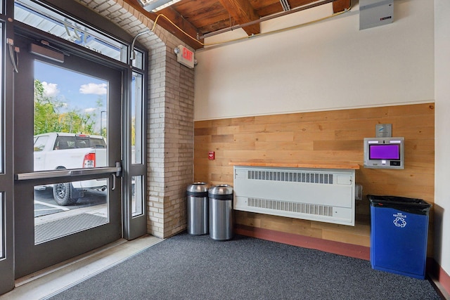 interior space featuring carpet flooring, heating unit, and wooden walls