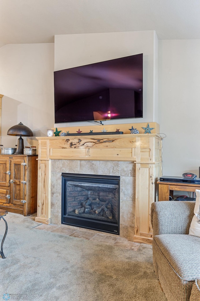 living room featuring a tiled fireplace and light colored carpet