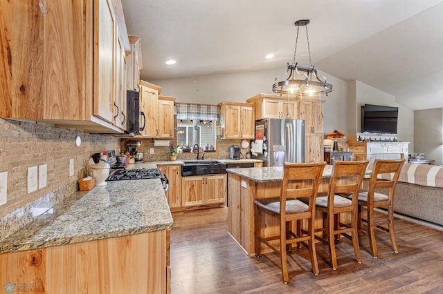 kitchen featuring lofted ceiling, dark hardwood / wood-style floors, stainless steel appliances, and a kitchen island