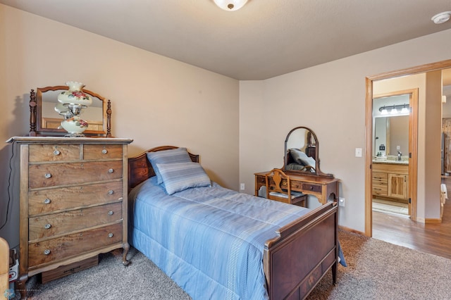 bedroom featuring connected bathroom, sink, and carpet floors