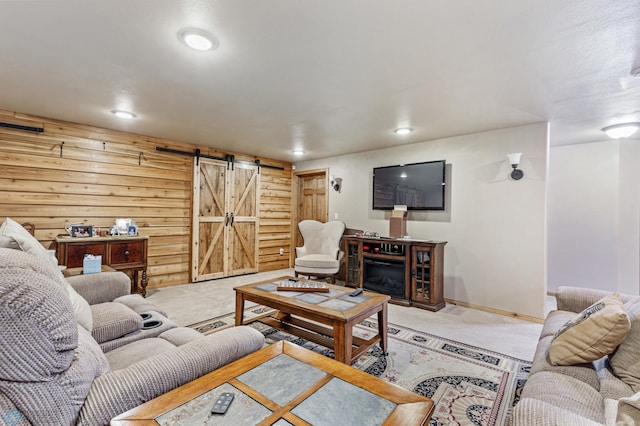 carpeted living room with wooden walls and a barn door