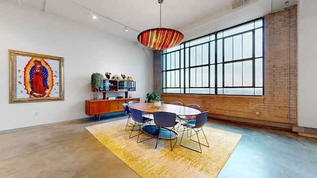 dining room with a towering ceiling and concrete floors