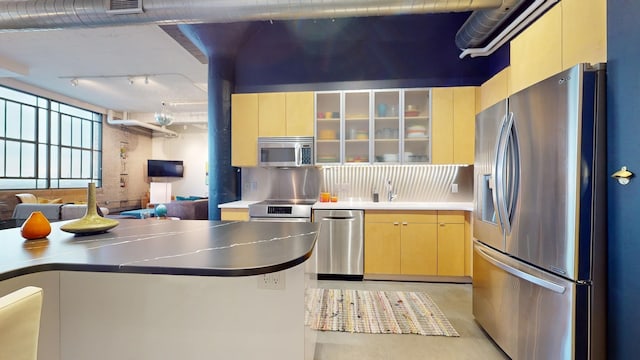 kitchen featuring backsplash, sink, stainless steel appliances, and light brown cabinetry