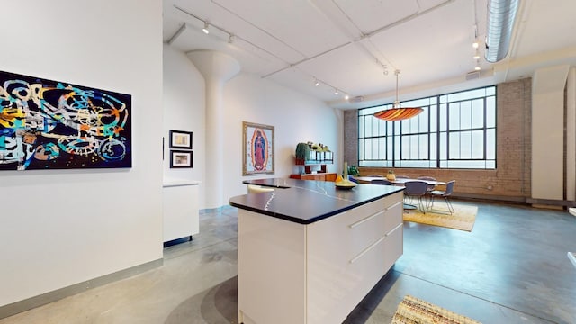 kitchen featuring white cabinetry, hanging light fixtures, and track lighting