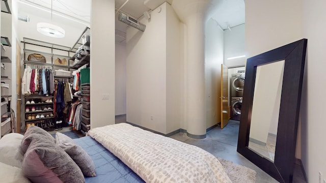 bedroom featuring stacked washer / drying machine, a closet, and concrete floors