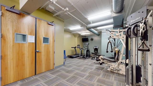 workout area featuring wooden walls and carpet floors