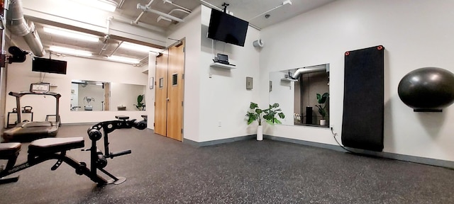 workout area featuring a high ceiling and baseboards